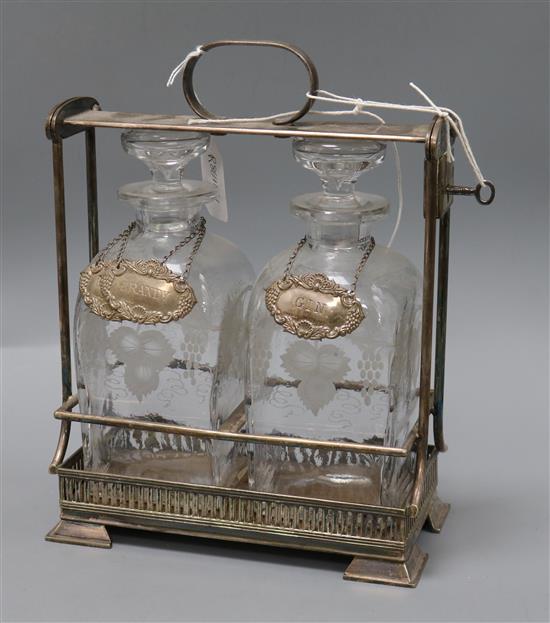 An Asprey silver plated tantalus with two decanters and three modern silver labels, Whisky, Brandy and Gin